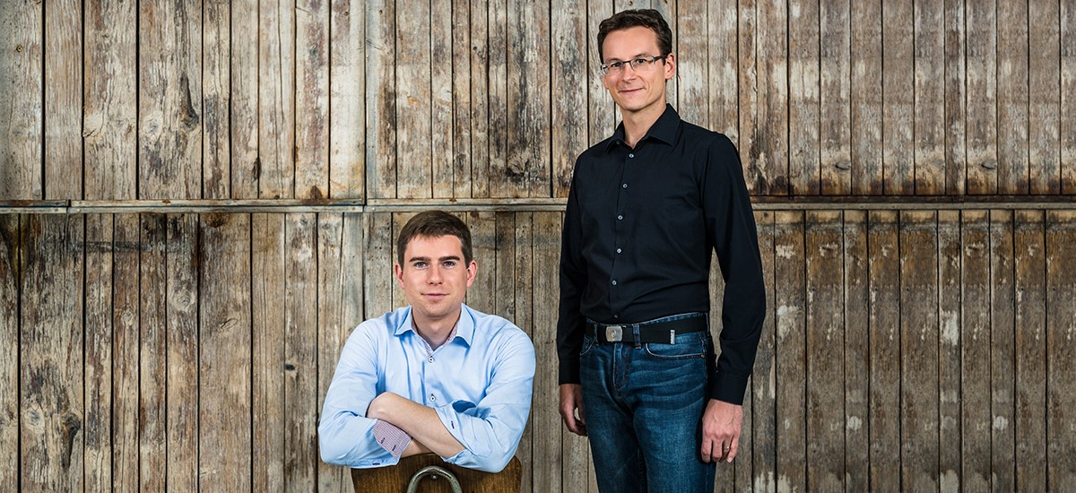 Die Geschäftsführer der Idea Distillers Christian Schrade und Simon Weiß vor einer Holzwand