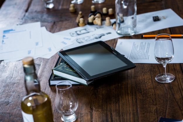 Gläser, Flaschen, Zeichnungen, Korken, ein Stapel Bücher und ein Tablett auf einem Holztisch: Die Idea Distillers beraten zum Thema Social-Media-Marketing (Foto)